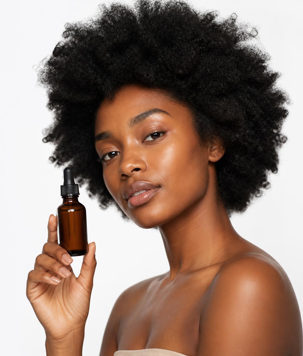 Femme aux cheveux naturels texturés appliquant un soin capillaire